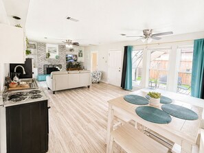Eine moderne Küche mit Essbereich, Kamin und Blick auf den Garten.