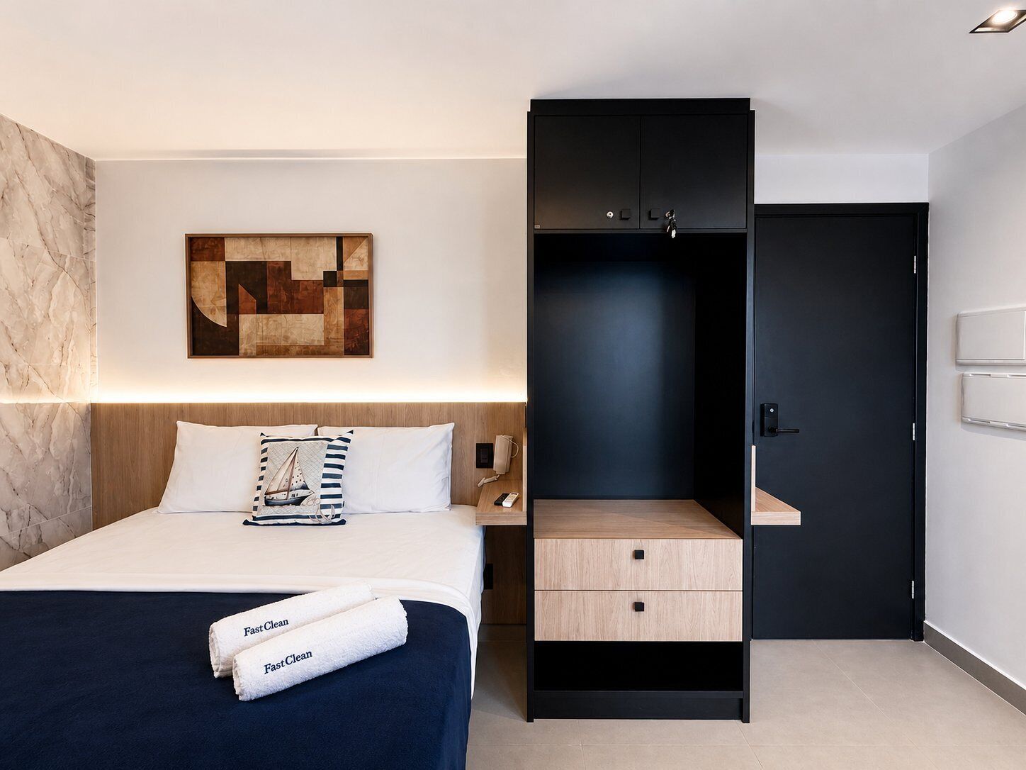 Una habitación de hotel moderna con una cama, una mesita de noche, un armario y una pared de mármol.