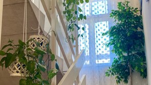 A staircase with a white railing, a hanging wicker basket, and a potted plant. - Comfort Studio Apartment - Studio Apartment with Garden View (Kastel Luksic)