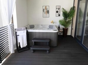 Ein Wellnessbereich mit Whirlpool, einer Sitzbank, einem Handtuchhalter und zwei gerahmten Kunstwerken an der Wand.