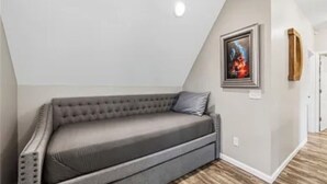 Una stanza in stile loft con un divano grigio, un quadro incorniciato appeso al muro e un pavimento in legno.