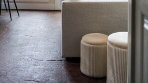 Un interior moderno con un sofá, otomanas y un comedor con sillas.