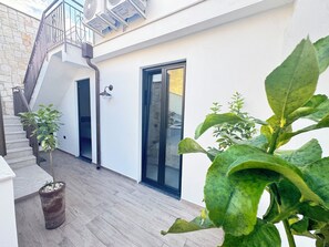 A modern building with a staircase, a door, and potted plants. - Kymata Home (Avola)
