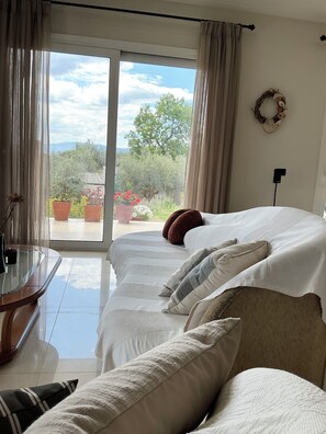 Ein Schlafzimmer mit Bett, Schreibtisch und Blick ins Freie.