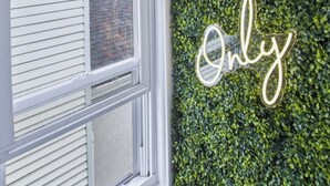 A wall with a green leafy texture and a neon sign that reads 'Good Vibes Only.' - Cozyluxstays FIFA World Cup Stay  Luxury 2BR + Game Room Near MetLife Stadium (Belleville)