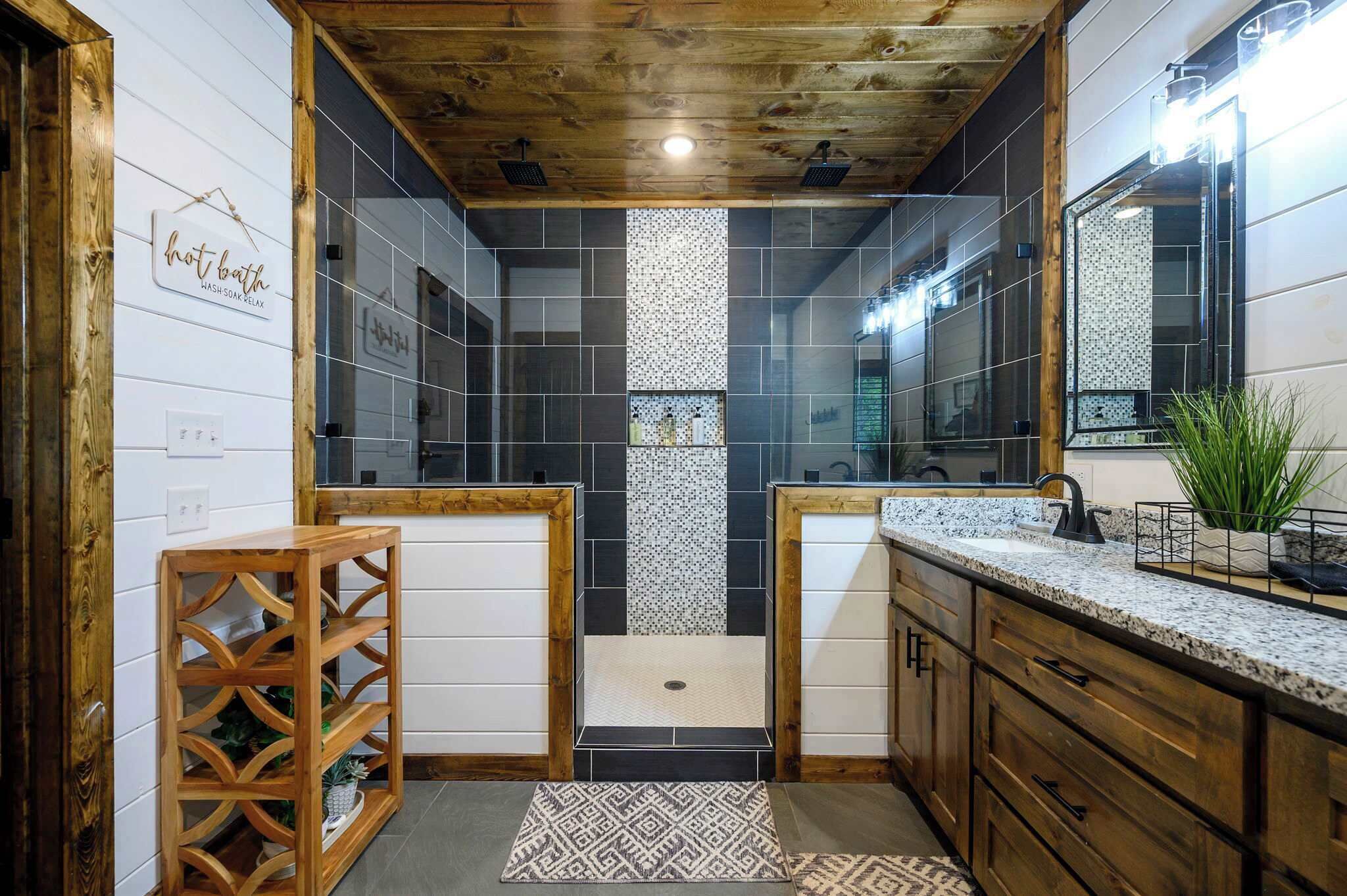 Une salle de bain avec un plafond en bois, un lavabo, un miroir et un espace douche.