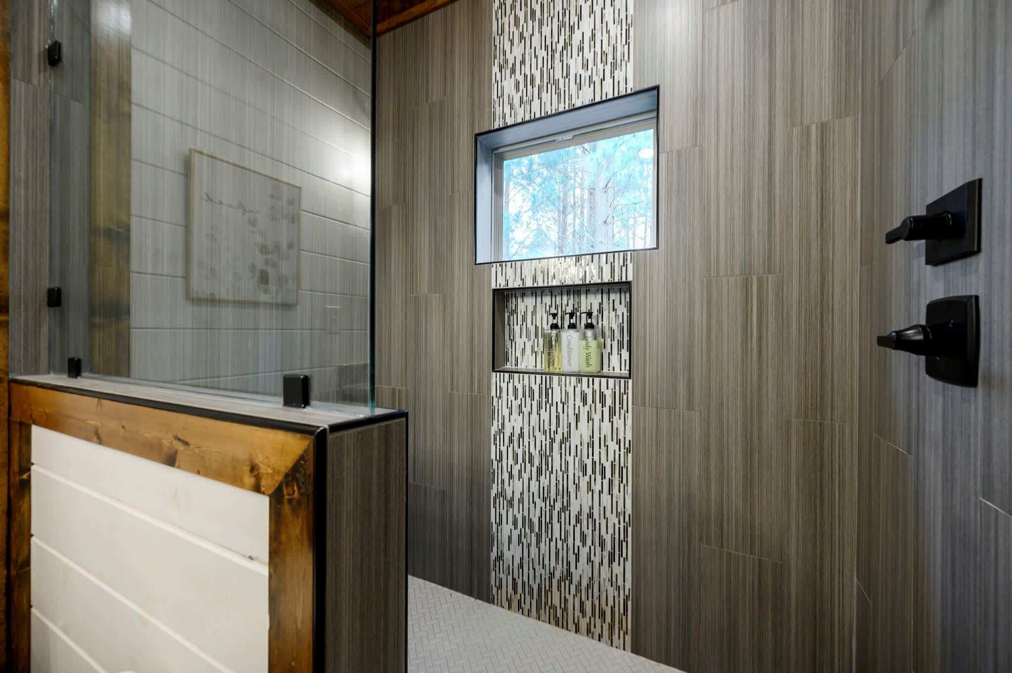 Un baño moderno con tocador de madera, pared estampada y ventana.