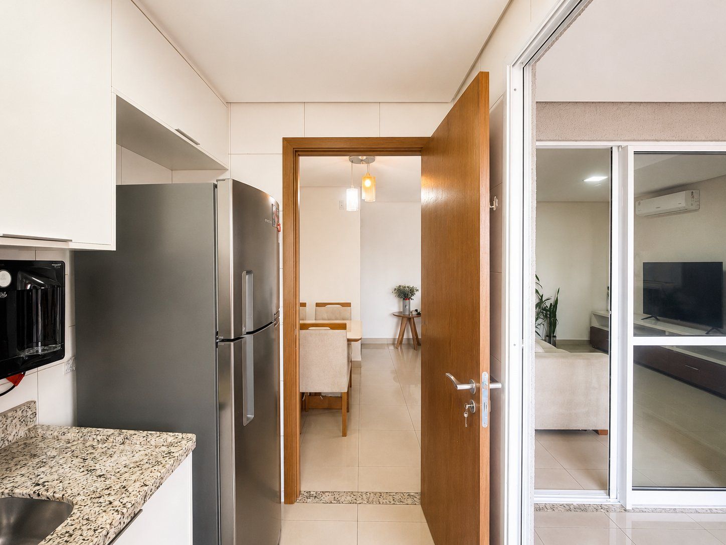 A modern kitchen with a stainless steel refrigerator, a microwave, and a coffee machine.