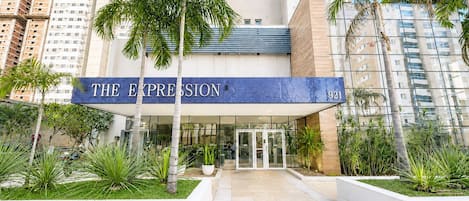 A hotel entrance with a blue sign reading 'THE EXPRESSION 921'.