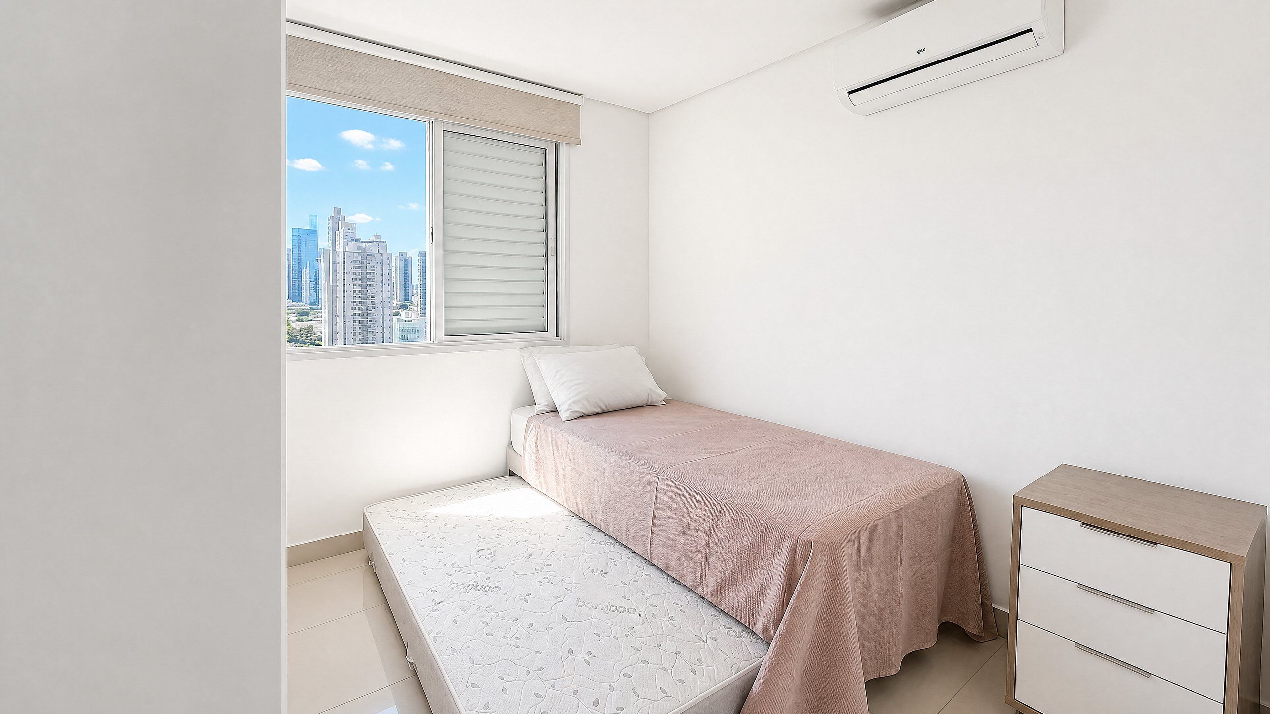 Un dormitorio con cama, mesita de noche, ventana con persianas y unidad de aire acondicionado.