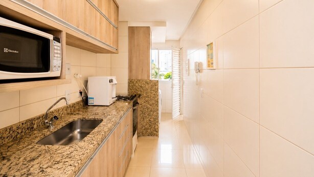 A kitchen with a microwave, toaster, and sink. - The Expression 2 Quartos (Goiânia)