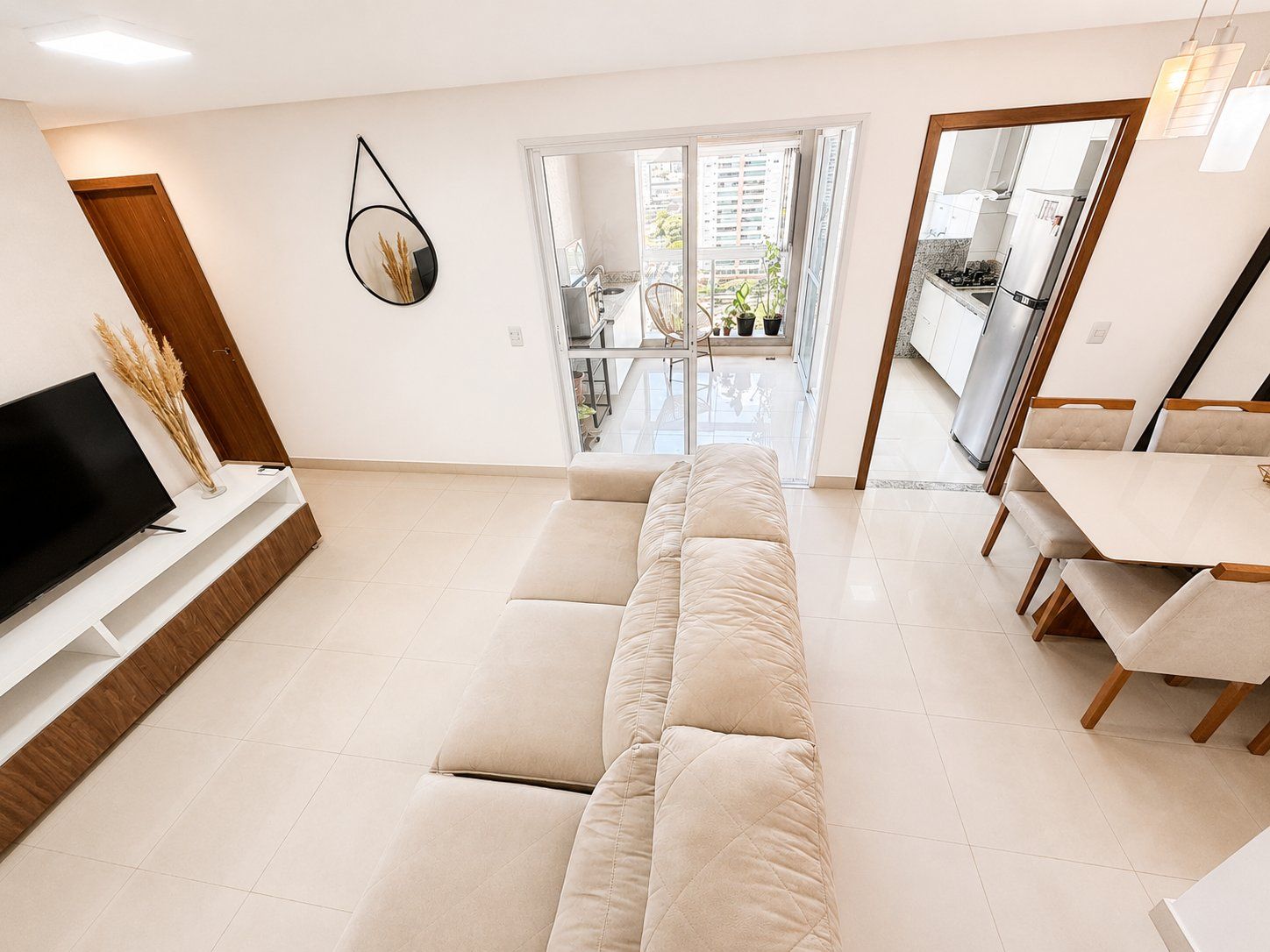 Una sala de estar moderna con sofá, televisión y comedor.