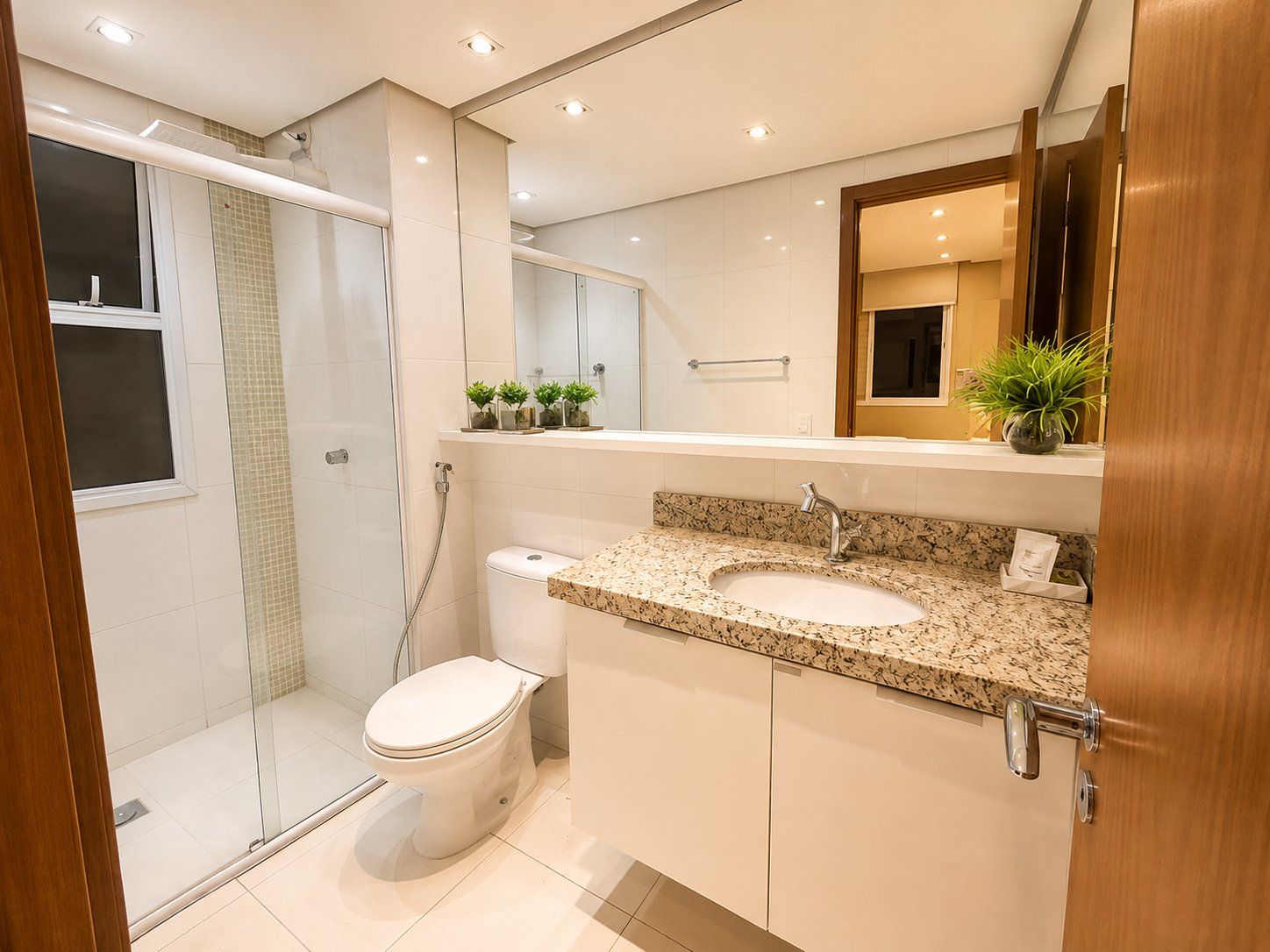 A modern bathroom with a shower, toilet, and sink.
