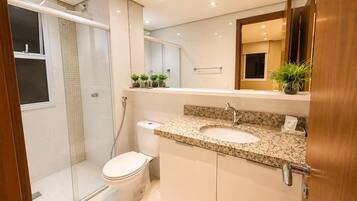 A modern bathroom with a shower, toilet, and sink.