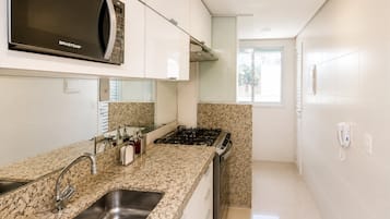 Una cocina moderna con encimeras de granito, electrodomésticos de acero inoxidable y un microondas integrado.