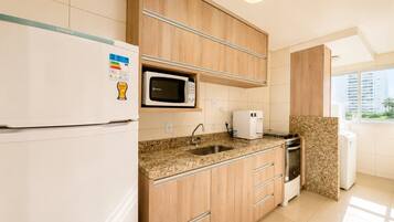 Una cocina moderna equipada con refrigerador, microondas, cafetera y estufa.