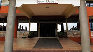 A hotel entrance with a sign reading 'Grabo & County Dream Hotel,' large pillars, and a brick facade.