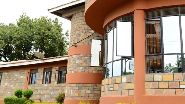 A building with a brick facade, large windows, and a satellite dish.