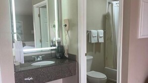 Ein Badezimmer mit Waschbecken, Spiegel, Toilette und Dusche.