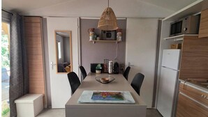 Una cuina moderna amb una illa central, electrodomèstics integrats i una zona de menjador amb un gran finestral.