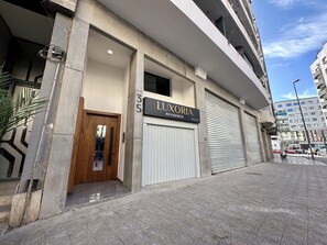 Rakennuksessa on kyltti, jossa lukee ”LUXORIA RESIDENCE”, ja sen autotalli on suljettu.