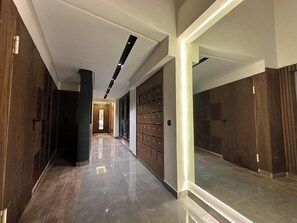 A modern hallway with wooden doors, a tiled floor, and a ceiling with recessed lighting. - Gauthier luxury studio (Casablanca)
