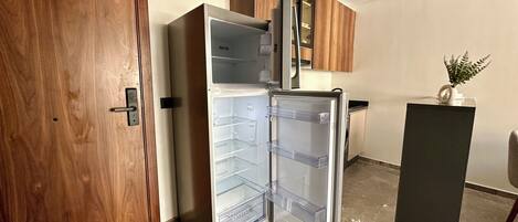 Una cocina moderna con refrigerador integrado, armarios de madera y piso de mármol.