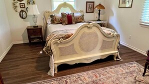 Une chambre à coucher avec un lit, une table de chevet, une lampe, une fenêtre et un tapis.