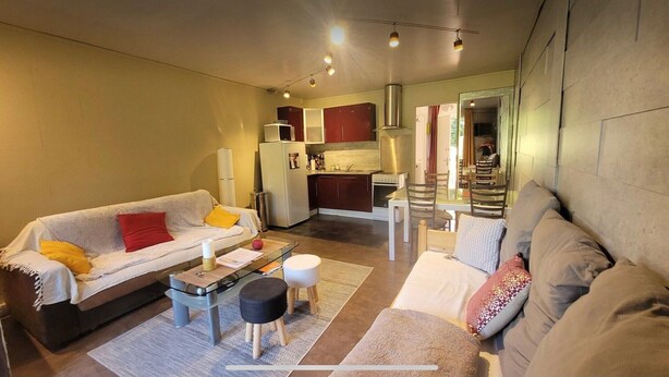 A compact living space with a sofa, a dining table, and a kitchenette. - Cosy mountain studio (Boutx)