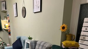 A living room with two plaid sofas, a cabinet, and a small table with a plant.