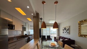 A modern kitchen with a glass dining table, stainless steel appliances, and pendant lighting. - Ipanema 2 Suites Ocean View 1min to Beach (Rio de Janeiro)