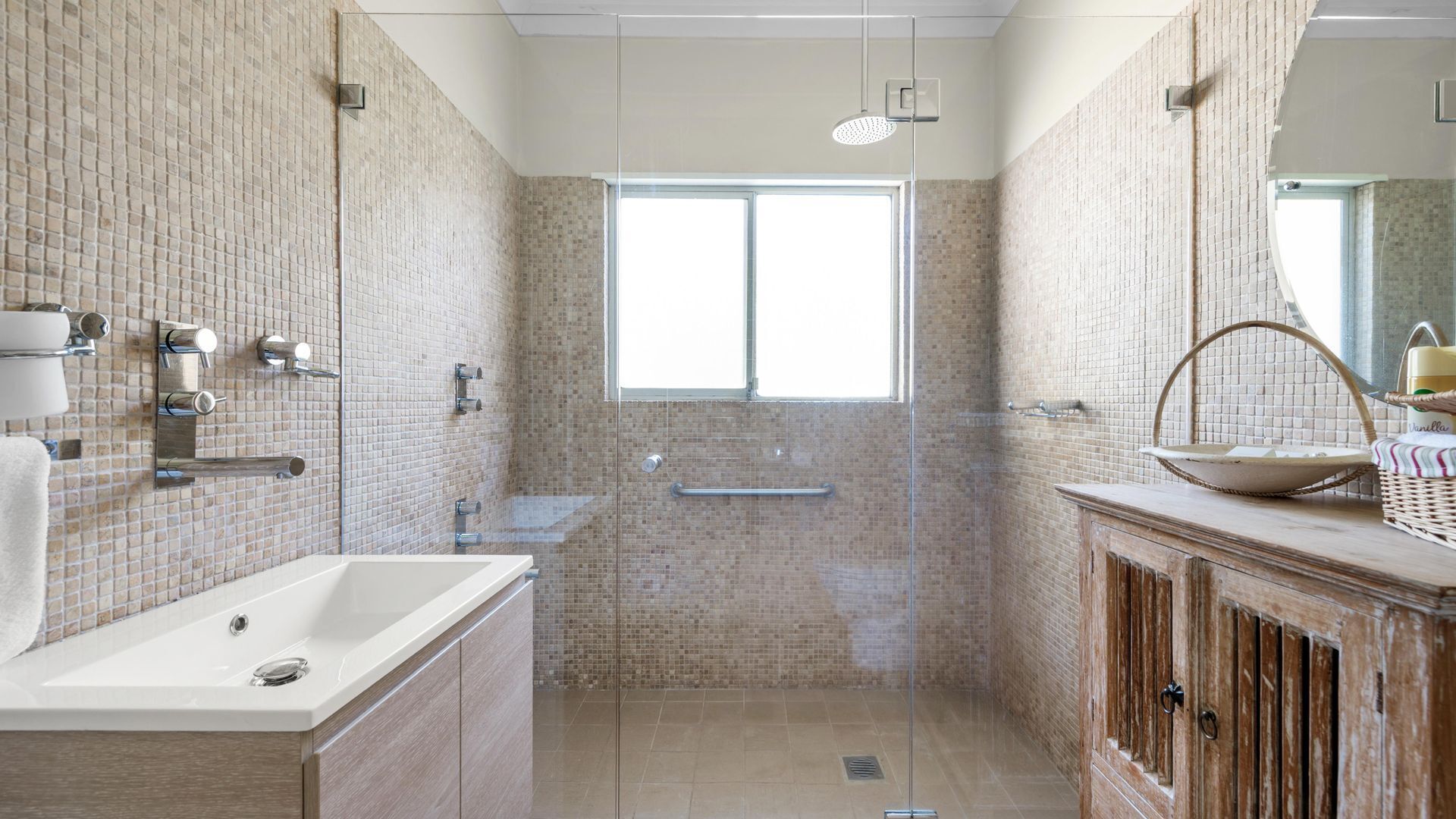 Une salle de bain moderne avec une douche à l’italienne, une grande fenêtre et un meuble-lavabo en bois.