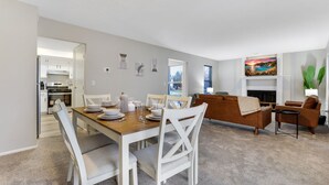 Un salon moderne comprenant un coin repas, une cheminée et une vue sur l’extérieur.