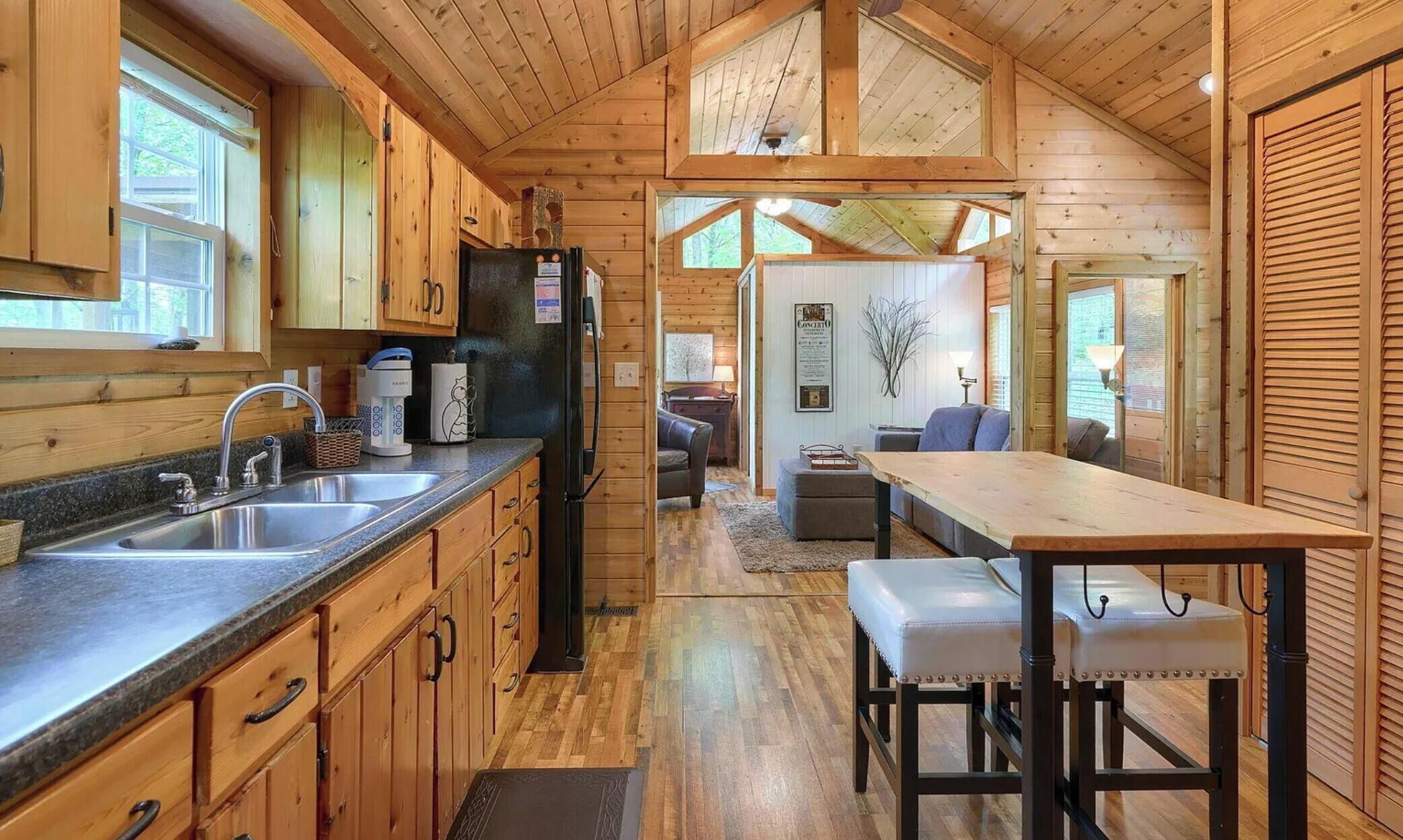L’intérieur d’une cabane en bois comprend une cuisine, un coin repas et un salon.