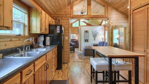 Ein Holzhaus-Interieur mit Küche, Essbereich und Wohnzimmer.