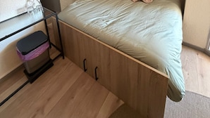 A compact room with a bed, a small desk, a TV, and a wardrobe. - Modern Beach Apartment Valras (Valras-Plage)