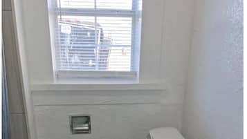Een douche, handdoeken, zeep, toiletpapier