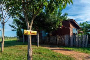 A wooden cabin with a sign reading 'Chalet Naturaza' in a rural setting. - Chal com Piscina Festival de Inverno de Bonito (Bonito)
