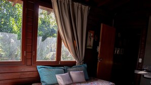 A room with a bed, a window with curtains, a wooden ladder, and a door. - Chal com Piscina Festival de Inverno de Bonito (Bonito)