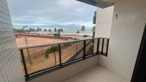 A balcony with a view of the beach, tiled walls, and a metal railing. - Atlantic View 309 - Elegance and Comfort on the Intermares Beachfront for 5 people (Cabedelo)