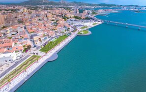 An aerial view of a coastal city with a prominent waterfront promenade, a marina, and dense urban buildings. - [Olbia] House with Wi-fi Parking near waterfront (Olbia)