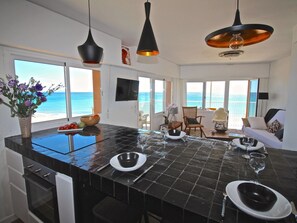A modern kitchen with a large island, black countertops, and a view of the sea. - APARTAMENTO COSTA BLANCA by Interhome (El Campello/Villajoyosa)