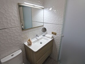 A bathroom with a white sink, a mirror, and a toilet. - ESTUDIO PLAYA MUCHAVISTA by Interhome (El Campello/Villajoyosa)