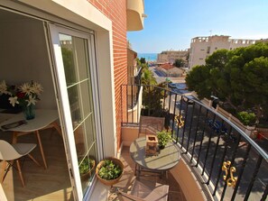 A balcony with a table, chairs, and potted plants. - APARTAMENTO SOL Y LUZ 3 by Interhome (El Campello/Villajoyosa)