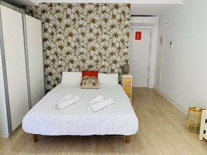 A hotel room with a bed, a wardrobe, a bedside table, and a door with a fire safety sign. - APARTAMENTO SOL Y LUZ 3 by Interhome (El Campello/Villajoyosa)
