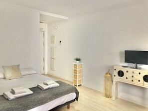 A bedroom with a bed, a dresser, a television, and a small plant. - APARTAMENTO SOL Y LUZ 1 by Interhome (El Campello/Villajoyosa)