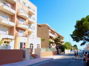 A multi-story residential building with balconies, a gated entrance, and a clear sky. - APARTAMENTO SOL Y LUZ 1 by Interhome (El Campello/Villajoyosa)