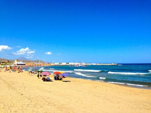 A beach with people, umbrellas, and boats in the background. - APARTAMENTO LAS TORRES by Interhome (El Campello/Villajoyosa)