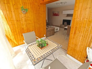 A modern interior with a dining area featuring a table with a patterned tablecloth, a chair, and a potted plant. - APARTAMENTO LAS TORRES by Interhome (El Campello/Villajoyosa)