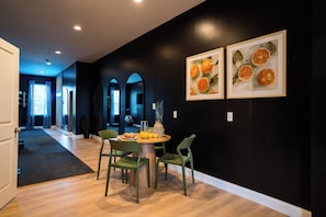 A dining area with a round table, chairs, and artwork on the wall. - StayAtlas Retreat w/ Pool, Gym, Sauna, Games, BBQ (St. Louis)